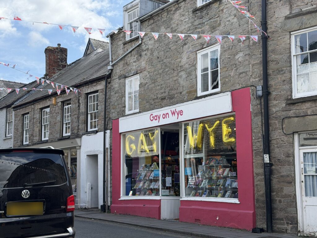 The red and white Gay on Wye bookshop on a stone street hung with bunting